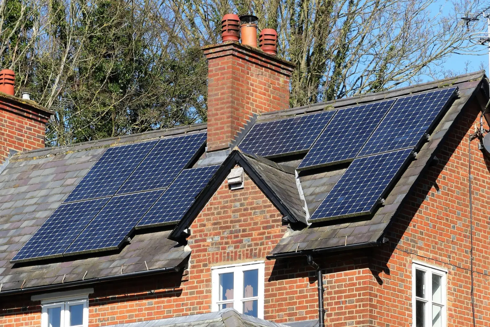 Solar panels installed on the tiled roof of a brick house